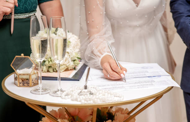 istock Caucasian bride signs a document with the groom 2195928631