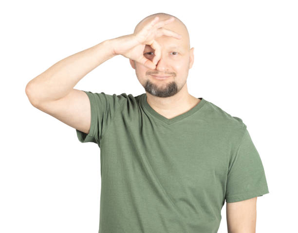 istock Playful man making an OK sign over his eye with a smile 2195928715