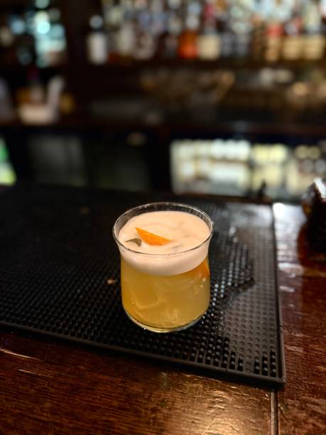 istock Whiskey sour cocktail at pub bar with orange peel 2195928788