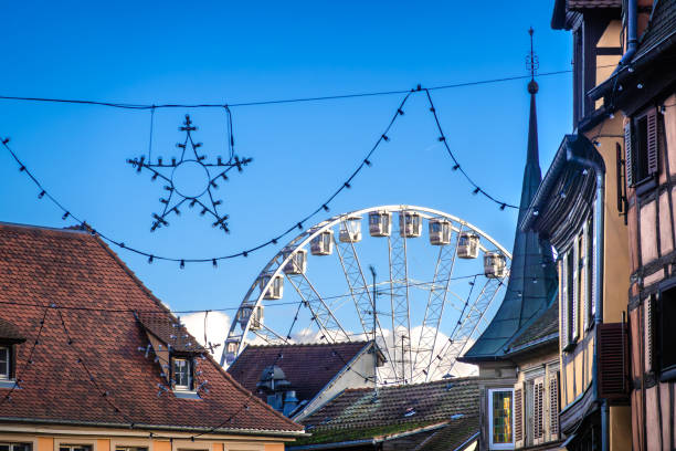 Colmar, France - November 28, 2024: Ferris Wheel Behind Rooftops of Colmar, Alsace, with Christmas decorations
