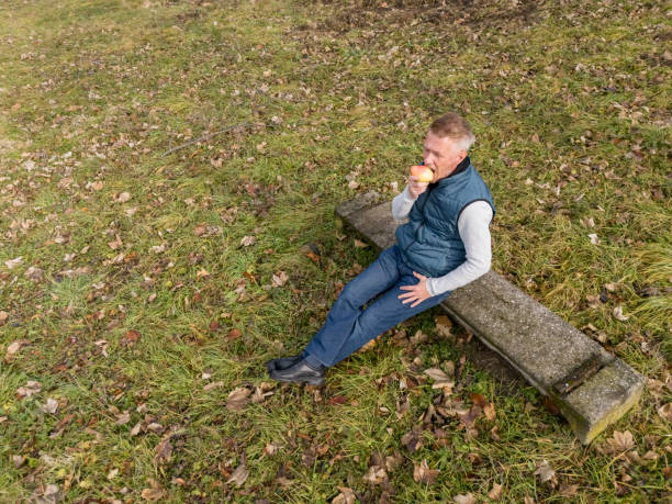 Man eats pear fruit while walk in the city