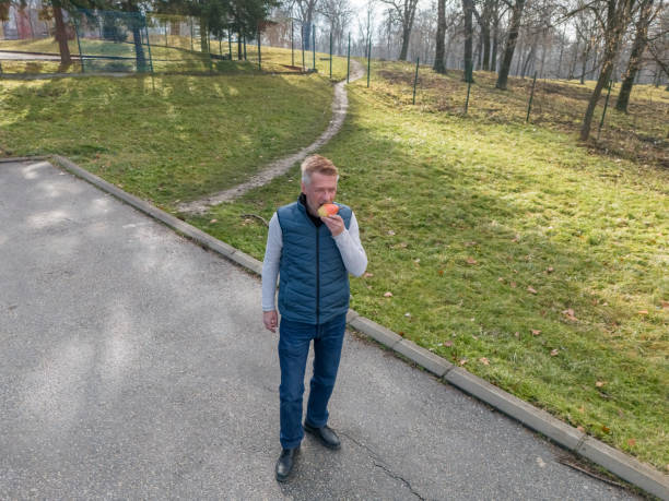 Man eats pear fruit while walk in the city