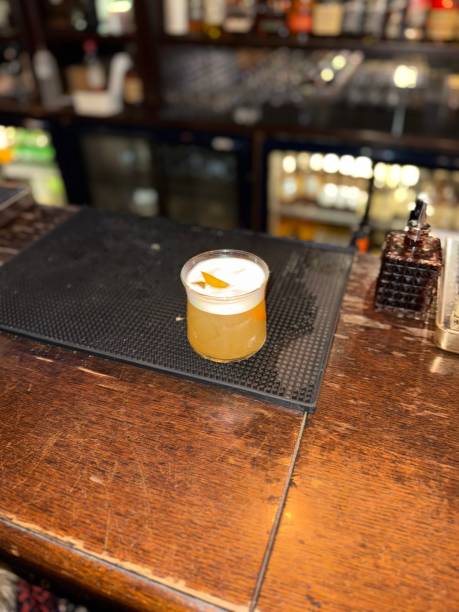 istock Whiskey sour cocktail at pub bar with orange peel 2195930417