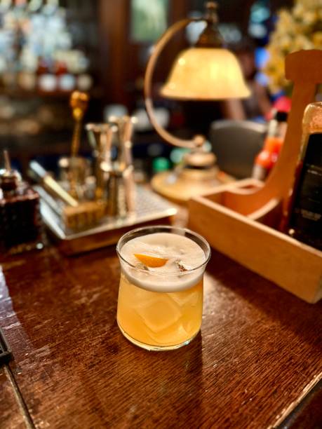 istock Whiskey sour cocktail at pub bar with orange peel 2195931951