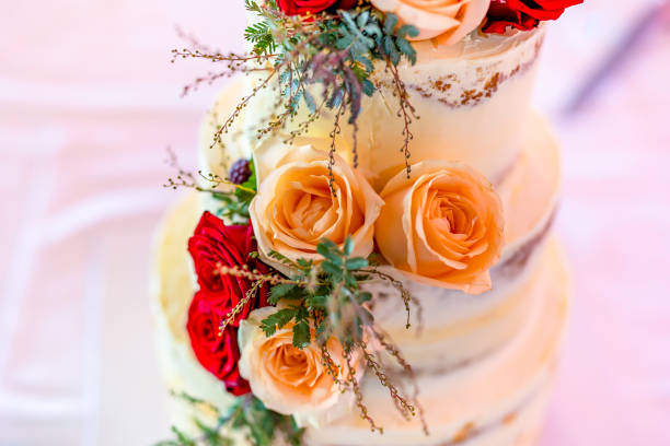 istock Beautiful wedding cake decorated with red and orange roses 2195937893