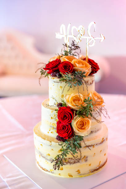 istock Beautiful wedding cake decorated with red and orange roses 2195938036