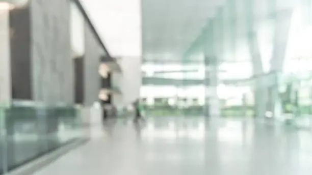 Blurred business office building lobby or hotel blur background interior view toward reception hall, modern luxury lounge, white room space with blurry corridor and glass wall Blurred business office building lobby or hotel blur background interior view toward reception hall, modern luxury lounge, white room space with blurry corridor and glass wall