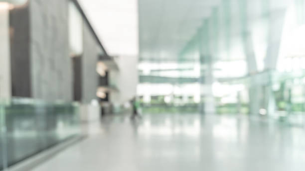 istock Blurred business office building lobby or hotel blur background interior view toward reception hall, modern luxury lounge, white room space with blurry corridor and glass wall 2195941735