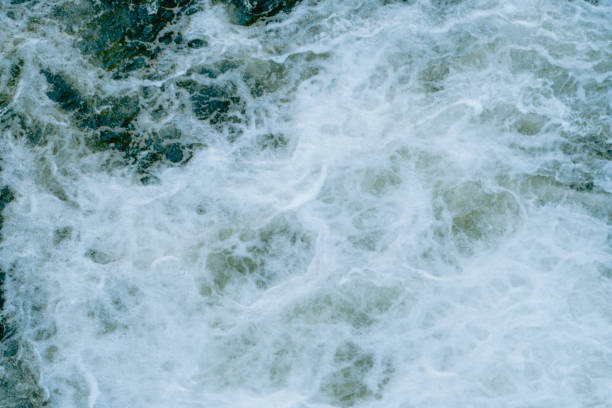 istock Churning ocean waves create intricate patterns near the shore under bright daylight during summer afternoon hours 2195942574
