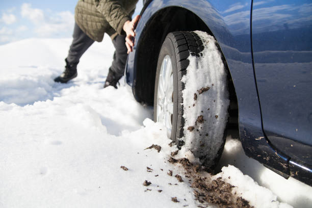 istock Pushing a Stuck Car on a Snowy Winter Road 2195943736