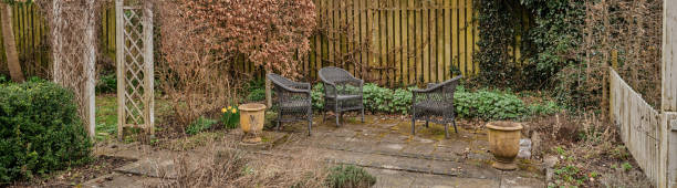 Wooden table and chair in the garden with tropical plants in pots