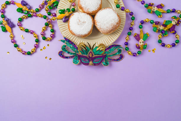 istock Carnival or mardi gras concept with carnival masks, polish donuts, beads and throws on purple background 2195952873