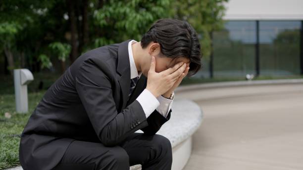 Businessman holding his head outside stock photo