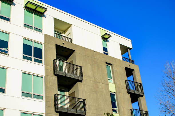 istock Low-angle view of modern apartment building exterior highlighting architectural details, horizontal lines, and black metal railings on stacked private balconies. 2195957664