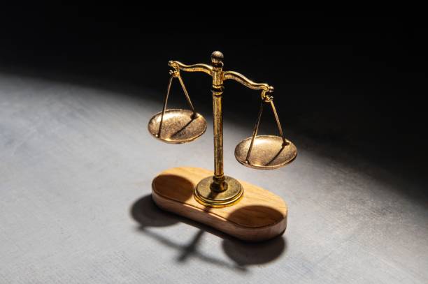 istock A scale of justice illuminated by a spotlight stands against a dark background. 2195961315
