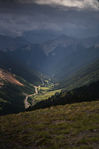 istock Scenic Mountain Valley with Lush Forests and Winding Road Under Moody Sky 2195966076