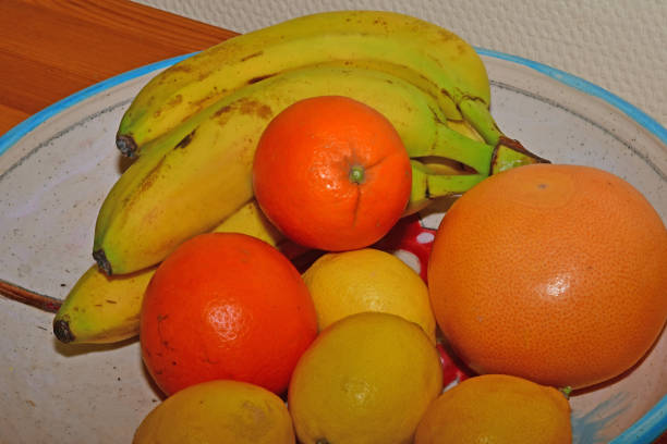 fresh fruits in a bowl on a plank