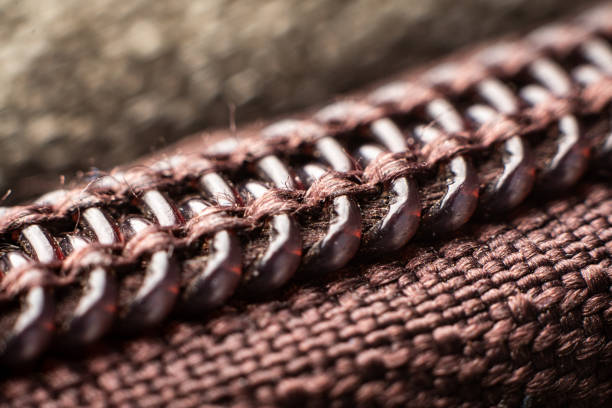 Close-up of a zipper reveals intricate details and patterns in its fabric and metal components, highlighting craftsmanship and durability in a creative way.