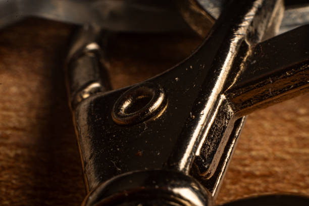 A macro view reveals a shiny metallic object resting on a warm wooden surface. The intricate details and textures create an eye-catching backdrop for creative design and decoration.