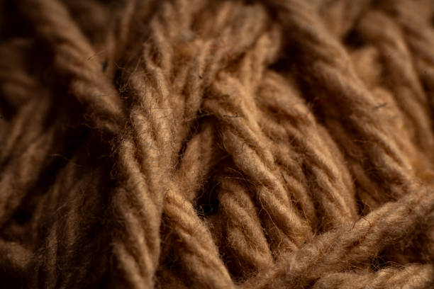 istock Creative weaving of natural brown yarn threads on textured fabric background ideal for textile designs 2195974243