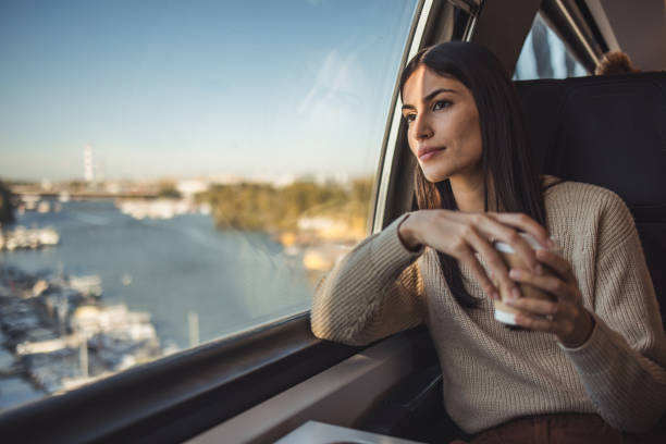 Female tourist on a train looking out the window