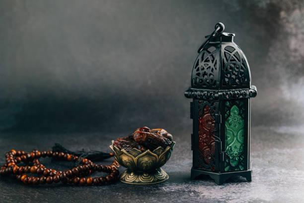 istock Decorative Ramadan scene with dates, prayer beads, and lantern, ideal for a meaningful Ramadan ambiance on dark background 2195982359
