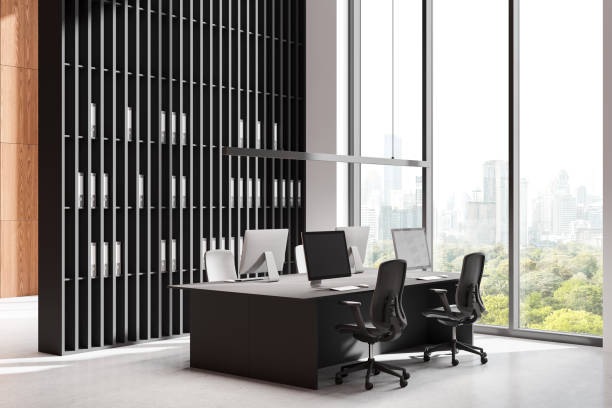 istock Modern office interior with large windows, city skyline view, and minimalist workstation setup with chairs and computers on a concrete floor. 3D Rendering 2195986463