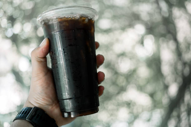 istock Takeaway plastic cup of iced black coffee in hand 2195986601