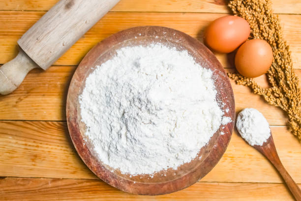 istock flour in a wooden bowl with eggs and a rolling pin beside it. 2195987184