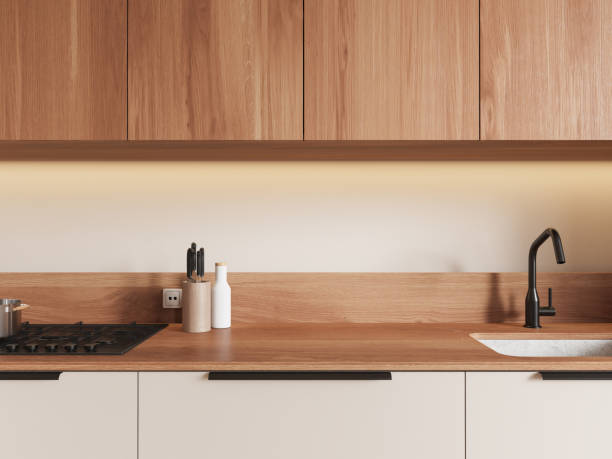 istock Modern kitchen interior with wooden cabinets, warm lighting, and sleek countertop featuring a sink, faucet, and gas stove. 3D Rendering 2195987815