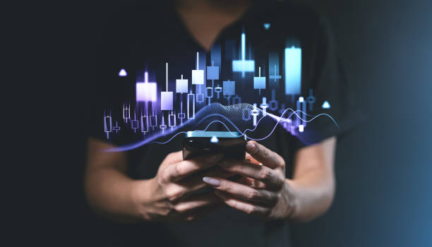 istock Financial chart and candlestick graph overlay on smartphone, held by person in dark background. 2195987903
