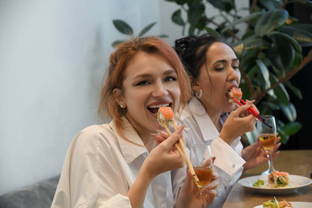 istock Friends enjoying sushi and drinks during a cozy gathering in a modern restaurant, sharing laughter and delicious food 2195988280
