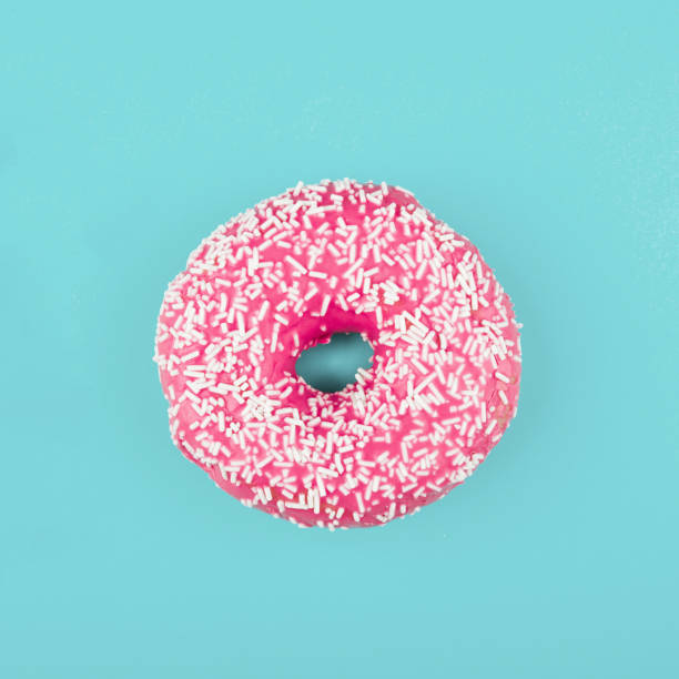 istock Pink donut on color background, flat lay, top view 2195988300