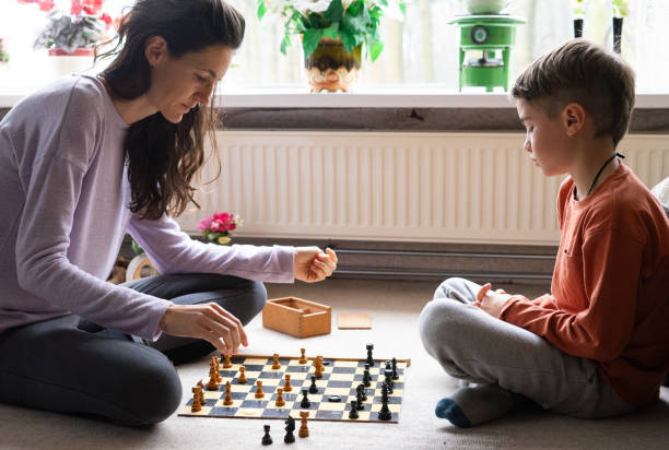 istock Mother and son having fun playing chess at home 2195988834