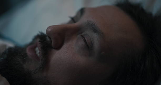 istock Patient lying in bed, eyes closing tightly as if experiencing epileptic seizures 2195991785