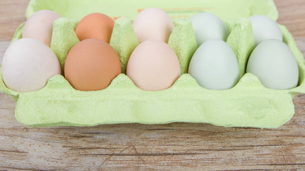 istock Eggs in a green carton on a wooden background. 2195991915
