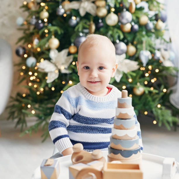 istock Cute little boy is playing with toy wooden train, toy car, pyramid and cubes, learning development concept. Development of kids fine motor skills, imagination and logical thinking 2195994549