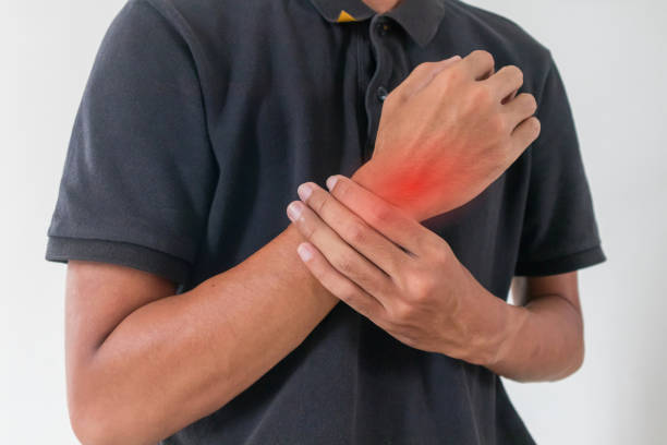istock A man holding his sore or painful wrist 2195995742