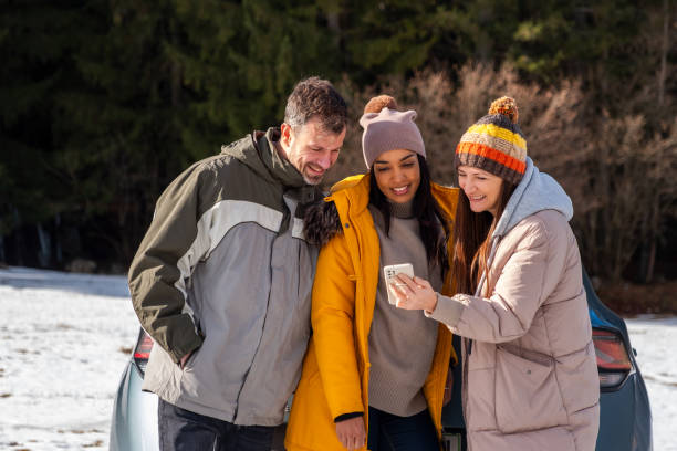 istock Friends Enjoying Smartphone Outdoors in Winter 2195995840
