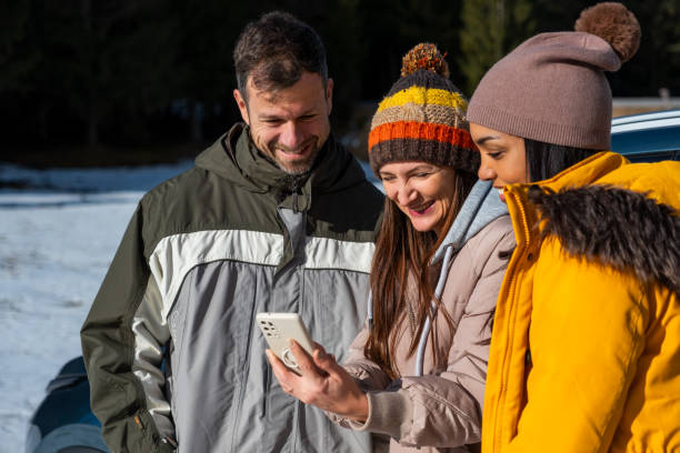 istock Friends Enjoying Smartphone Outdoors in Winter 2195995845