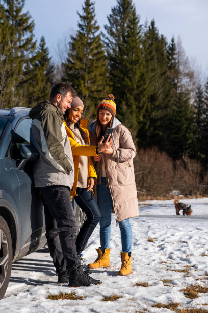 istock Friends Enjoying Smartphone Outdoors in Winter 2195996050