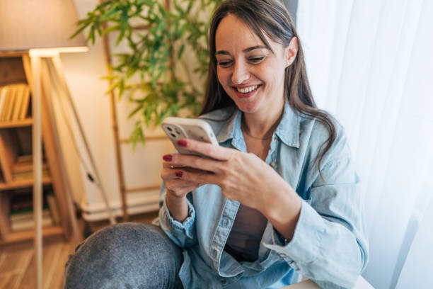 istock A woman is sitting at the dining table, using her phone. 2195996062