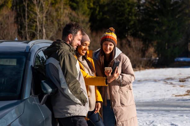 istock Friends Enjoying Smartphone Outdoors in Winter 2195996080