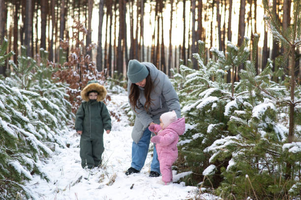 istock Winter fun: family playing and exploring a snowy forest 2196001469