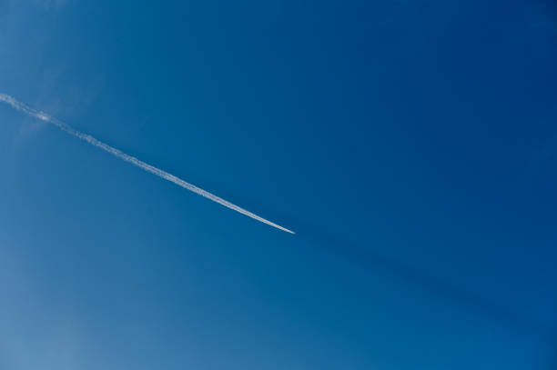 istock Contrails create delicate patterns across the bright blue sky during a sunny day 2196001853