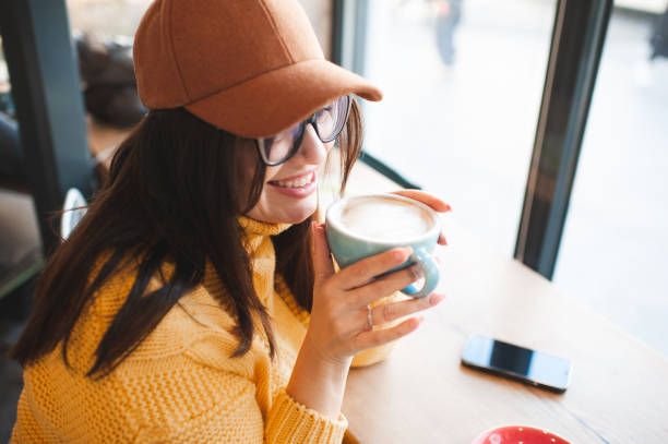 istock Young woman drinking coffee in cafe 2196002173