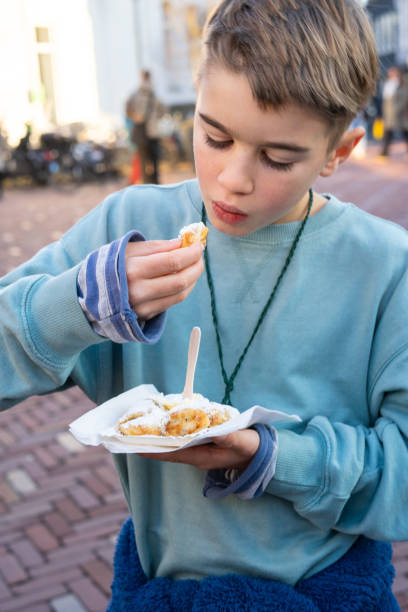 istock Boy eating poffertjes in amsterdam, netherlands 2196003501