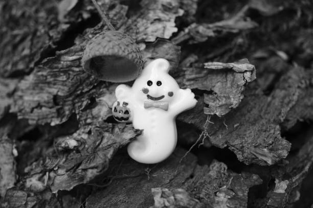 A toy ghost on a wooden background.