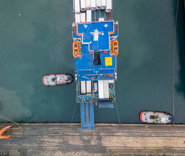 istock Aerial top view Tugboat pushing cargo ship to port. 2196011941