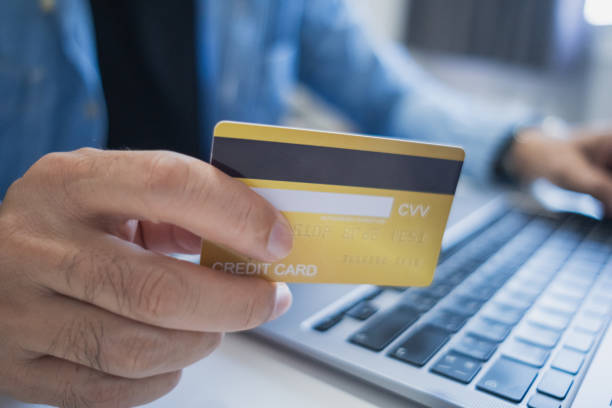 istock Close up, Man holding credit card while using laptop, shopping online, buying on internet. e-commerce e-banking service. 2196012366